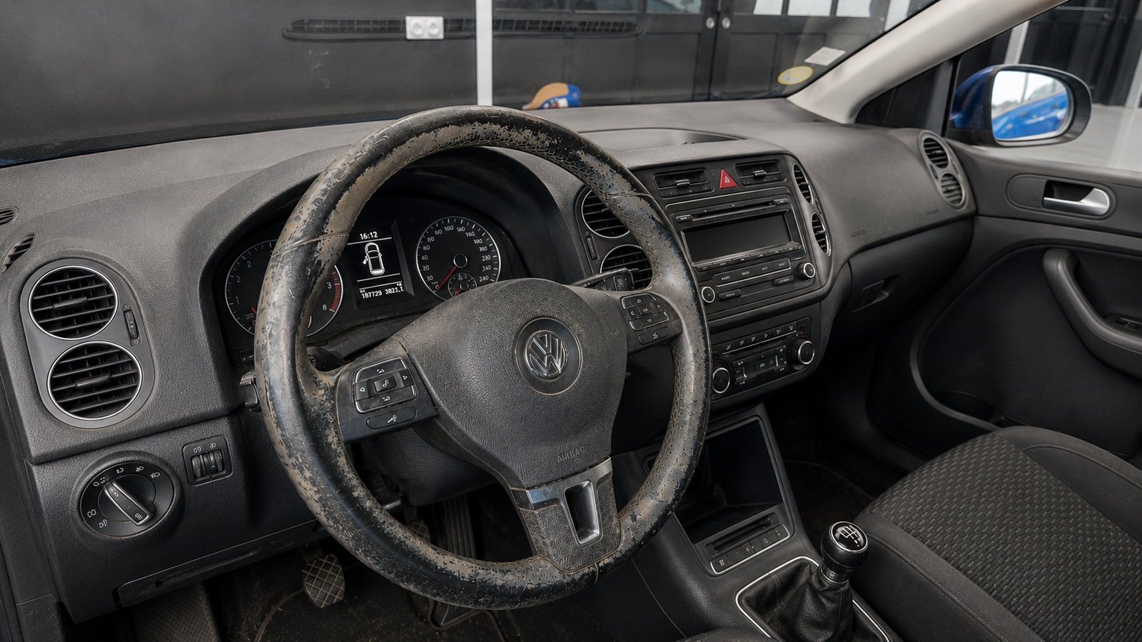 Volant et tableau de bord d'une Volkswagen encrassés, volant lustré et plastiques poussiéreux, avant nettoyage